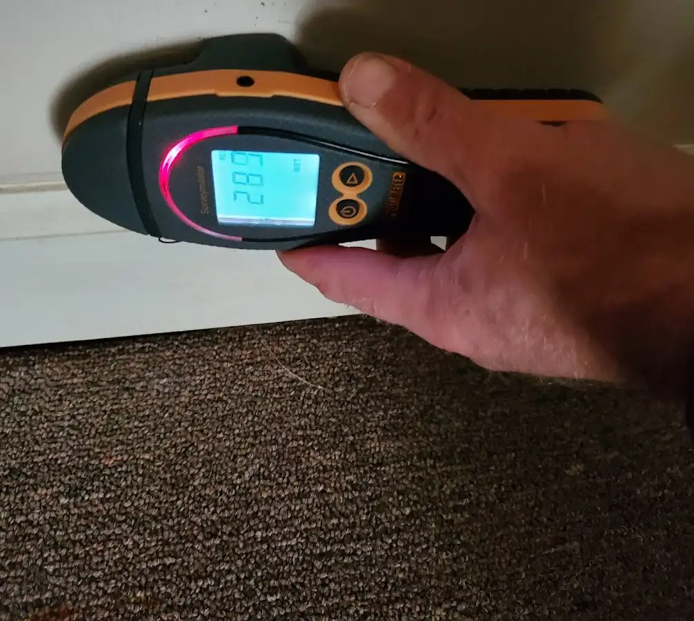 Moisture detection at baseboard during Storm Damage Restoration in Linton Hall